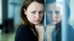 Traurige Frau an einem Fenster